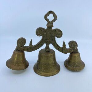 vintage brass triple bell with ornate handle and intricate detailing